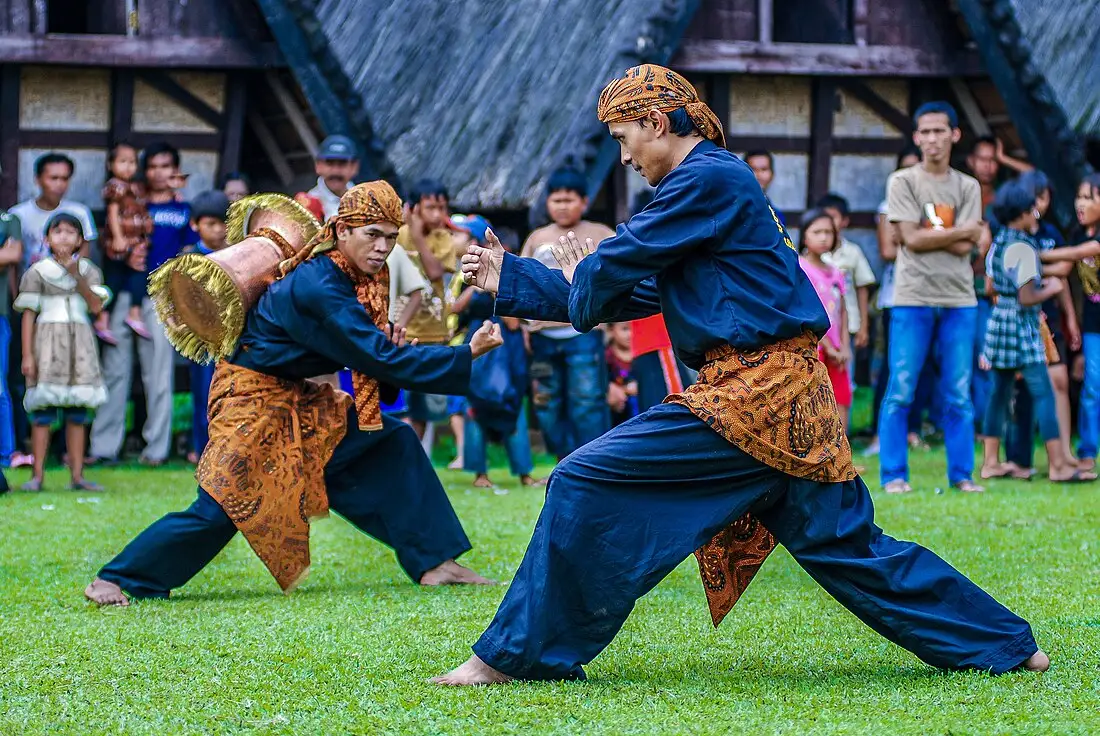 dua pria melakukan tradisi parebut seeng